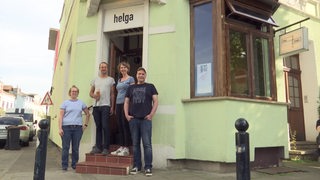 Mitglieder des Vereins zur Rettung der Eckkneipe "Helga" in Walle. Sie stehen vorm Eingang des hellgrün gestrichenen Hauses.