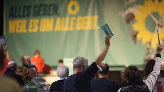 Delegierte stimmen bei einem Parteitag ab.
