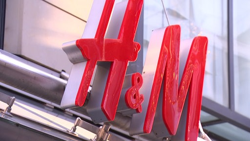 Das rote Logo von "H und M" an einem Gebäude.