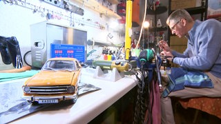 Ein Miniaturauto steht in der Werkstatt eines Modellbauers