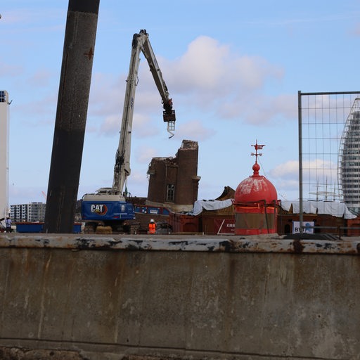 Ein Kran reißt teile des Molenturms in Bremerhaven ab: In seiner Zange klemmt ein Fenster