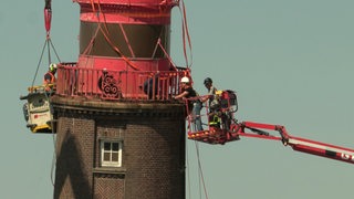 Mehere Menschen arbeiten an dem Abbau der Kuppel des Molenturms in Bremerhaven.