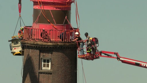 Mehere Menschen arbeiten an dem Abbau der Kuppel des Molenturms in Bremerhaven.
