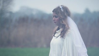 Eine Braut steht im vernebeltenm Teufelsmoor.