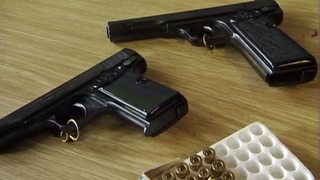 Zwei Pistolen liegen neben Patronenhülsen