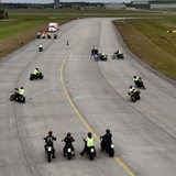 Motorräder fahren auf einer breiten Fahrbahn.