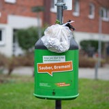 Ein übervoller Abfallbehälter mit dem Aufkleber: Sauber, Bremen!