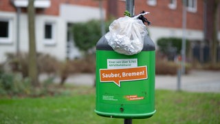 Ein übervoller Abfallbehälter mit dem Aufkleber: Sauber, Bremen!