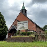 Vor einer Kirche steht ein Schild.