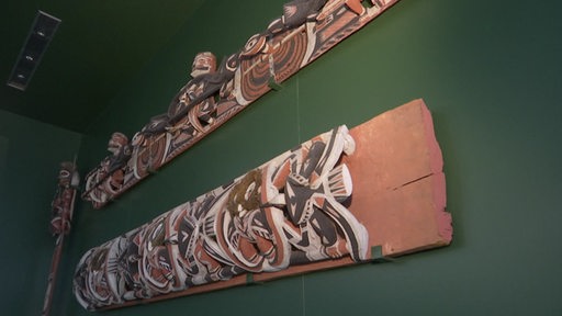 An der Wand im Überseemuseum hängen geschnitzte Sklupuren von ehemaligen Kolonien.