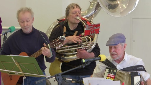 Eine Band aus älteren Menschen spielt ein Musikstück