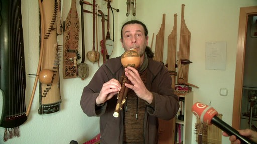 Der Multiinstrumentalist Ingo spielt ein Instrument aus Südostasien. 