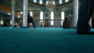Männer beten in einer Moschee.