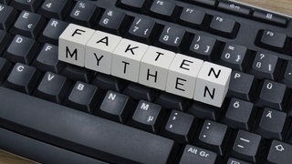Tastatur, auf der Buchstabenwürfel liegen mit der Aufschrift: "Mythen-Fakten"