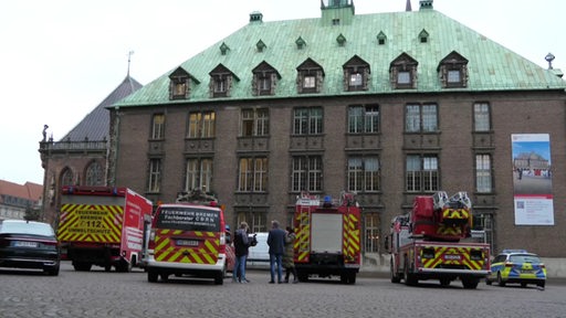 Polizei und Feuerwehr Fahrzeuge sammeln sich um das Bremer Rathaus. 