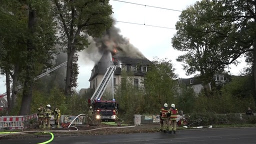Der Dachstuhl einer Villa in Horn-Lehe steht in Flammen, die Einsatzkräfte bekämpfen den Brand von außen. 
