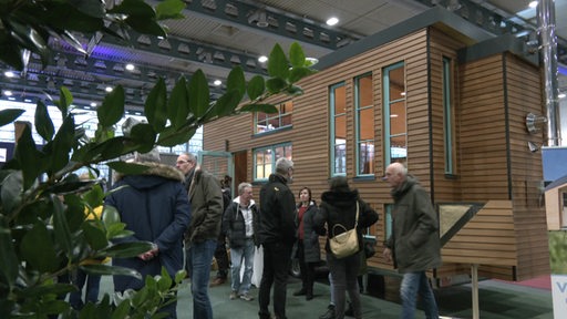 Menschen vor einem Haus auf der Hansebau und Bremer Altbautagen Ausstellung.