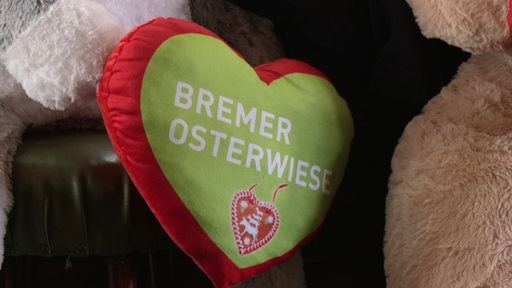Ein rotes und grünes Kissen wo Bremer Osterwiese draufsteht. 
