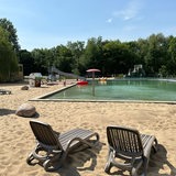 Strand mit Liegen und Strandkörben mit Blick auf das Becken im Naturbad Bassum.