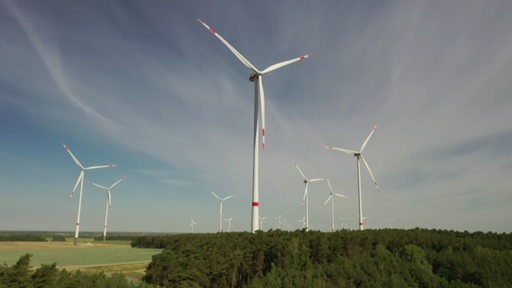 Mehrere Windkraftanlagen auf einem Feld.