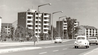 Heinrich-Plett-Allee mit Autoverkehr zwischen Wohnblöcken