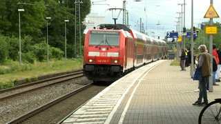 Menschen stehen am Bahnhof in Bremen-Sebaldsbrück und warten.