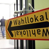 Ein Schild mit der Aufschrift "Wahllokal" hängt an einer geöffneten Tür.