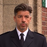 Polizeisprecher Nils Matthiesen steht in seiner Uniform vor einem Gebäude.