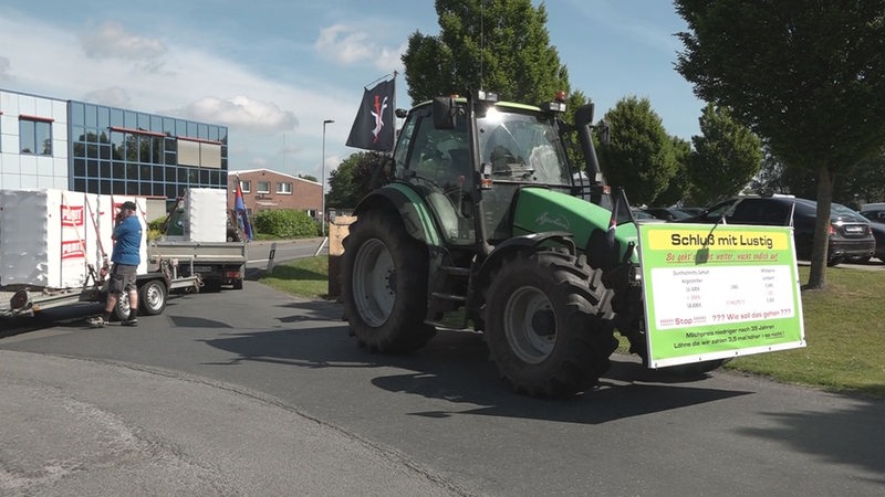 Ein Landwirt demonstriert mit seinem Traktor für höhere Milchpreise. Auf einem Plakat am Traktort steht "Schluss mit lustig".