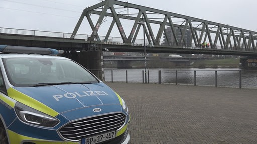 Polizeiauto vor Eisenbahnbrücke
