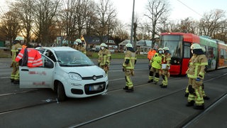 Mehrere Feuerwehrkräfte an einer Unfallstelle.