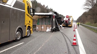Ein Lastwagen ist auf die Seite gekippt und blockiert eine Autobahnspur.