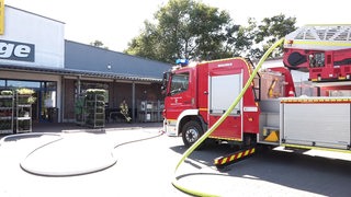 Ein Löschfahrzeug der Feuerwehr steht auf einem Supermarkt-Parkplatz