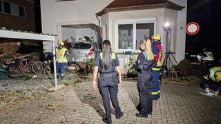 Polizisten an Unfallstelle in Oldenburg, Auto kracht in Haus