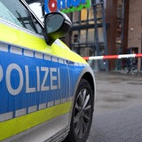 Ein Polizeiwagen steht vor einem Combi-Markt
