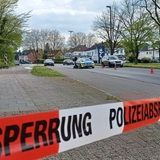 Eine von der Polizei abgesperrte Straßen, zwei Polizisten stehen auf der Straße.