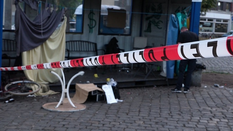 Eine Polizeiabsperrung ist vor einem halboffenen Container auf dem Lucie-Felchtmann-Platz angebracht.