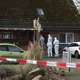 Spurensucher der Polizei im Schutzanzügen vor einem Haus
