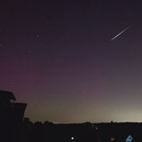Eine Sternschnuppe zieht über den Nachthimmel