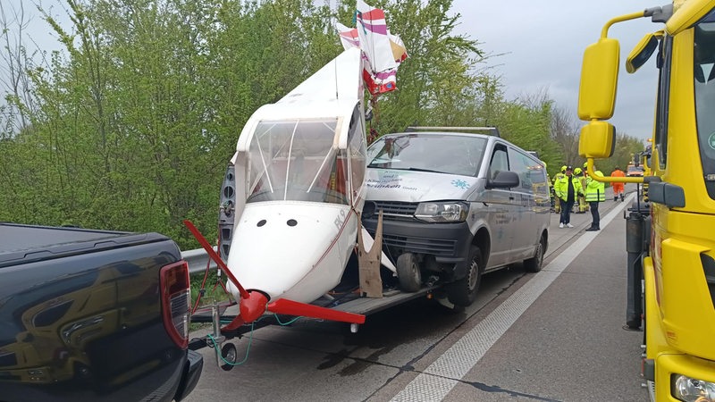Ein kaputtes Kleinflugzeug auf einUnfall, Autobahnem Autoanhänger auf einer Straße