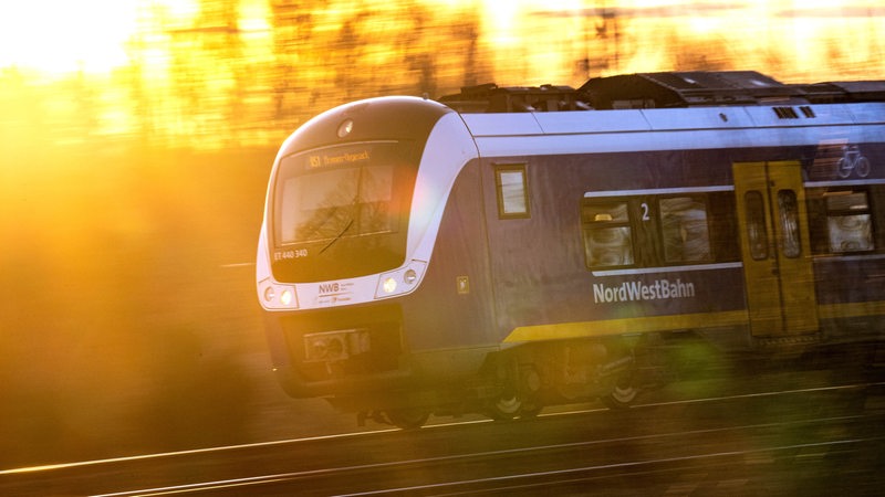 Ein Zug der NordWestBahn im Sonnenaufgang.