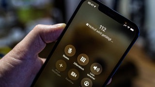 Eine Hand ruft auf dem Handy die Notrufnummer 112 (Symbolbild)