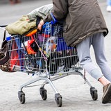 Ein obdachloser Mann läuft mit einem Einkaufwagen über den Platz vor dem Bremer Hauptbahnhof.