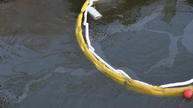Eine Ölsperre hält auslaufendes Öl auf der Weser auf