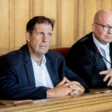Ein Mann sitzt auf der Anklagebank eines Gerichts. Neben ihm sein Anwalt. 