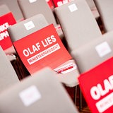 Pappen mit der Aufschrift «Olaf Lies - Ministerpräsident» liegen vor dem Sonderparteitag der SPD Niedersachsen auf Stühlen.