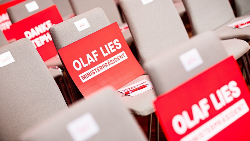 Pappen mit der Aufschrift «Olaf Lies - Ministerpräsident» liegen vor dem Sonderparteitag der SPD Niedersachsen auf Stühlen.