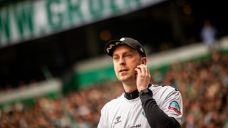Werder-Trainer Ole Werner kratzt sich an der Wange