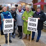 Eine Gruppe von älteren Frauen hält Plakate mit der Aufschrift "Omas gegen Rechts" in den Händen.