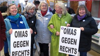 Eine Gruppe von älteren Frauen hält Plakate mit der Aufschrift "Omas gegen Rechts" in den Händen.